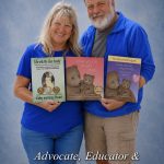 Smiling couple holding children's books, wearing matching blue shirts, standing against a blue background.