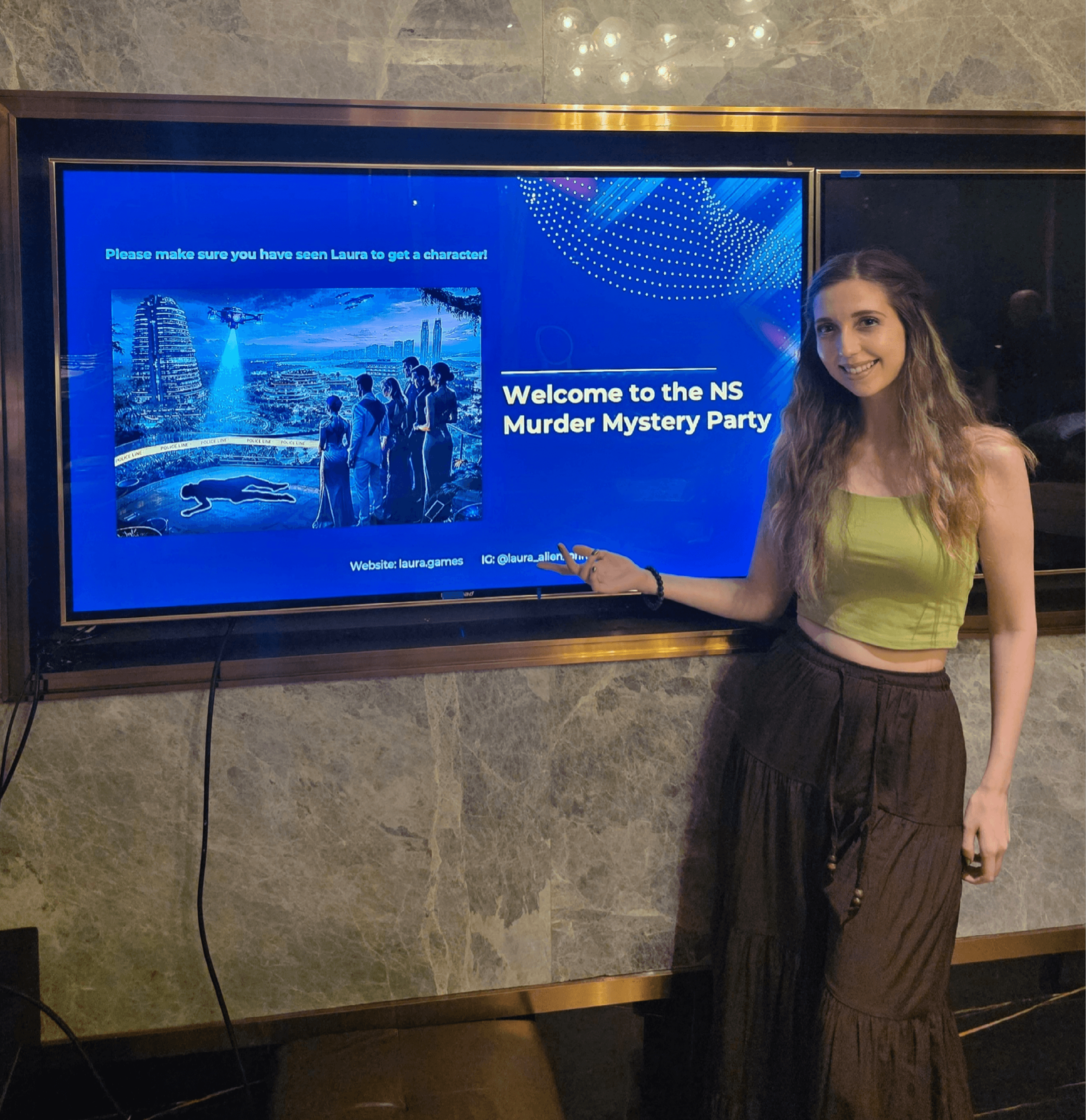 Woman standing next to a digital screen displaying a welcome message for the NS Murder Mystery Party.