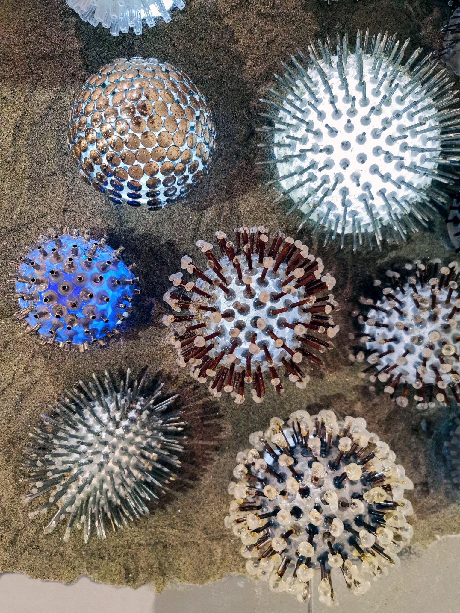 Collection of spiky, spherical objects with various colors and textures, arranged on a surface.