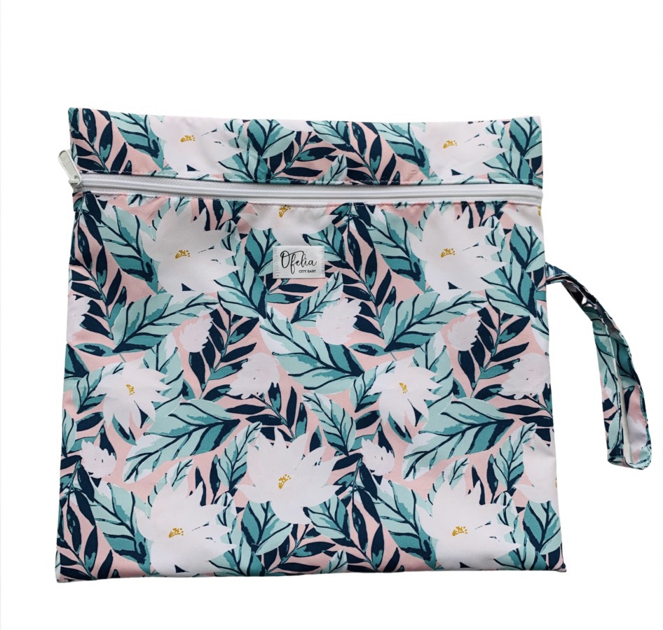 Fabric bag with a floral pattern of leaves and white flowers, zipper closure, and a strap on the side.